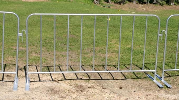 Three pedestrian barrier panels installed with flat feet stand on the lawn, they are interlocked with hook and loop.